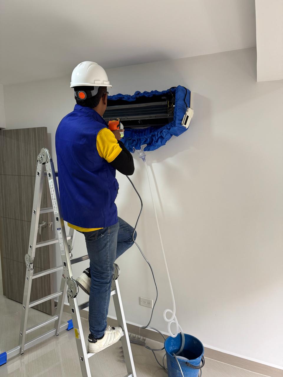 Técnico de Frío King haciendo mantenimiento a un split de pared en Medellín